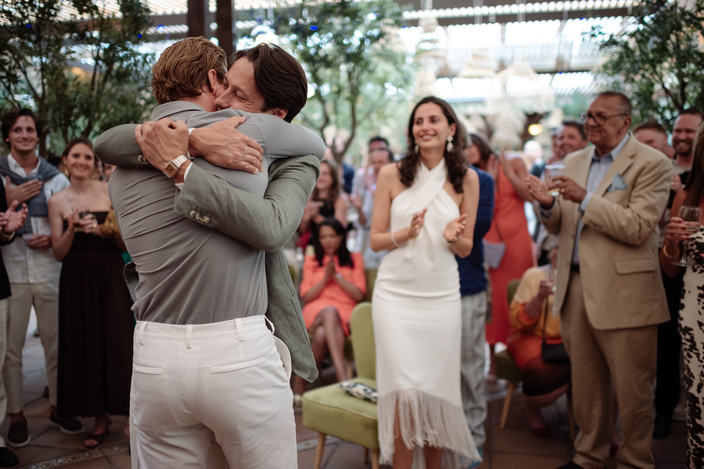 Abrazo emotivo entre familiares ante los invitados de una fiesta preboda