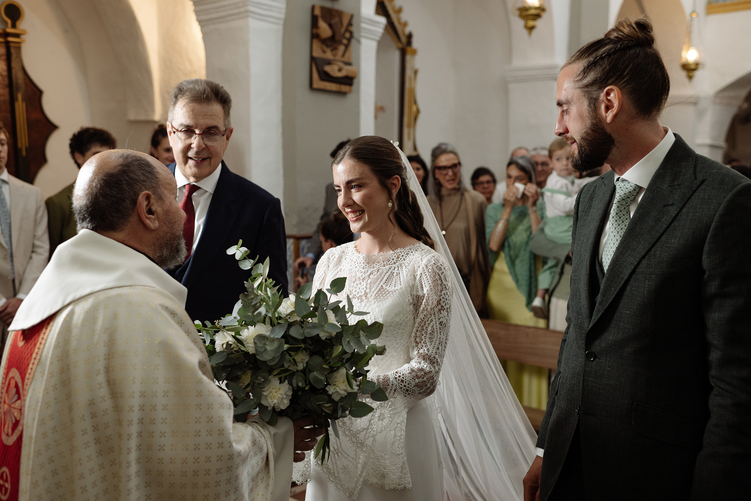 Los novios atienden al sacerdote durante la ceremonia religiosa