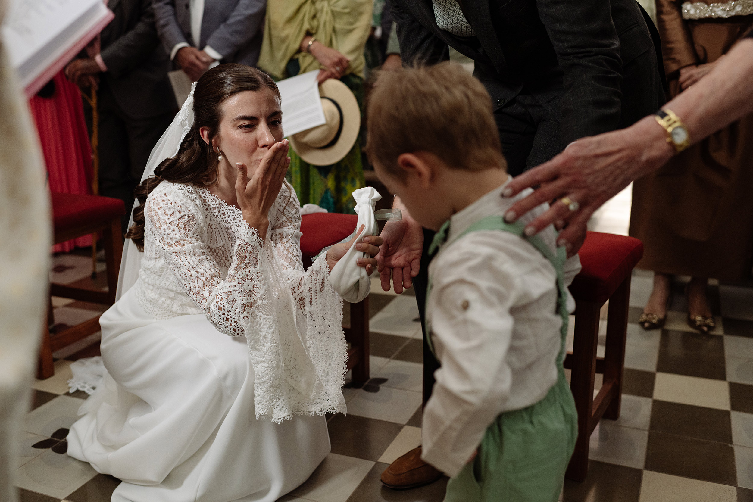 La novia se agacha para saludar a un niño durante la ceremonia