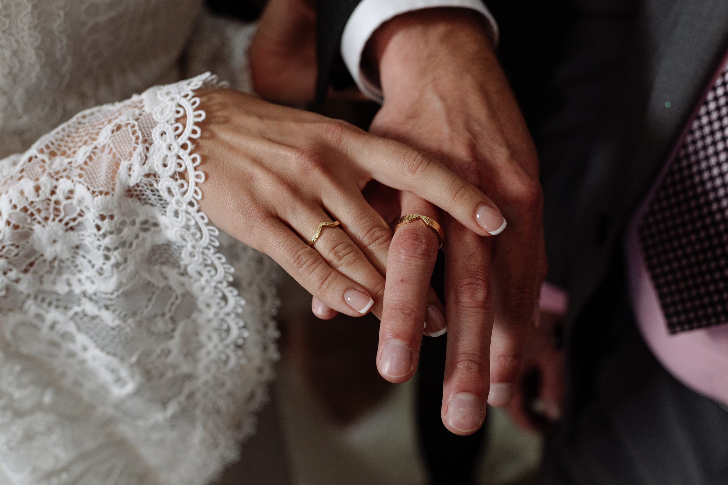 Las manos de la pareja muestran sus alianzas de boda