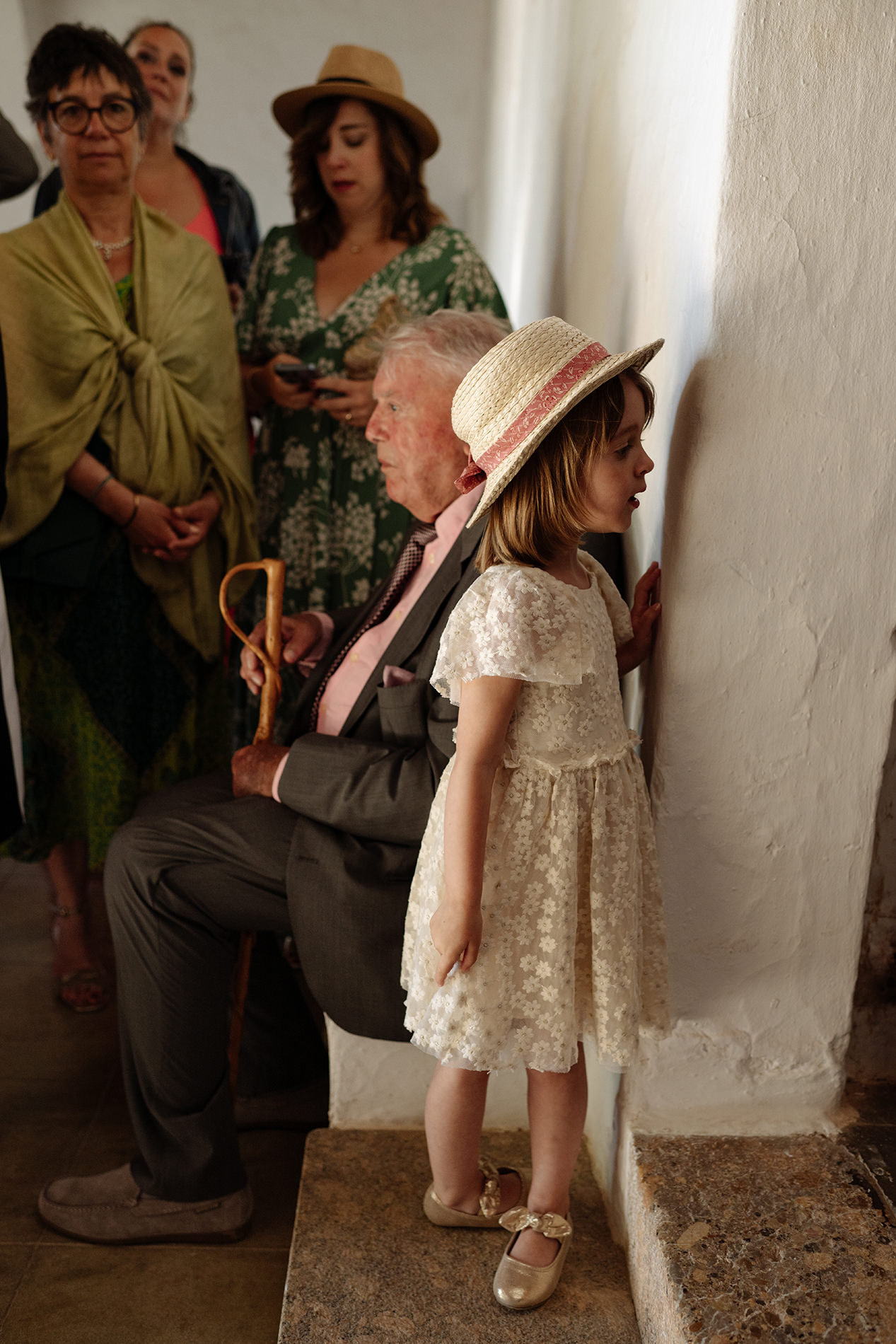 Niña con sombrero observa la ceremonia desde un lateral de la iglesia