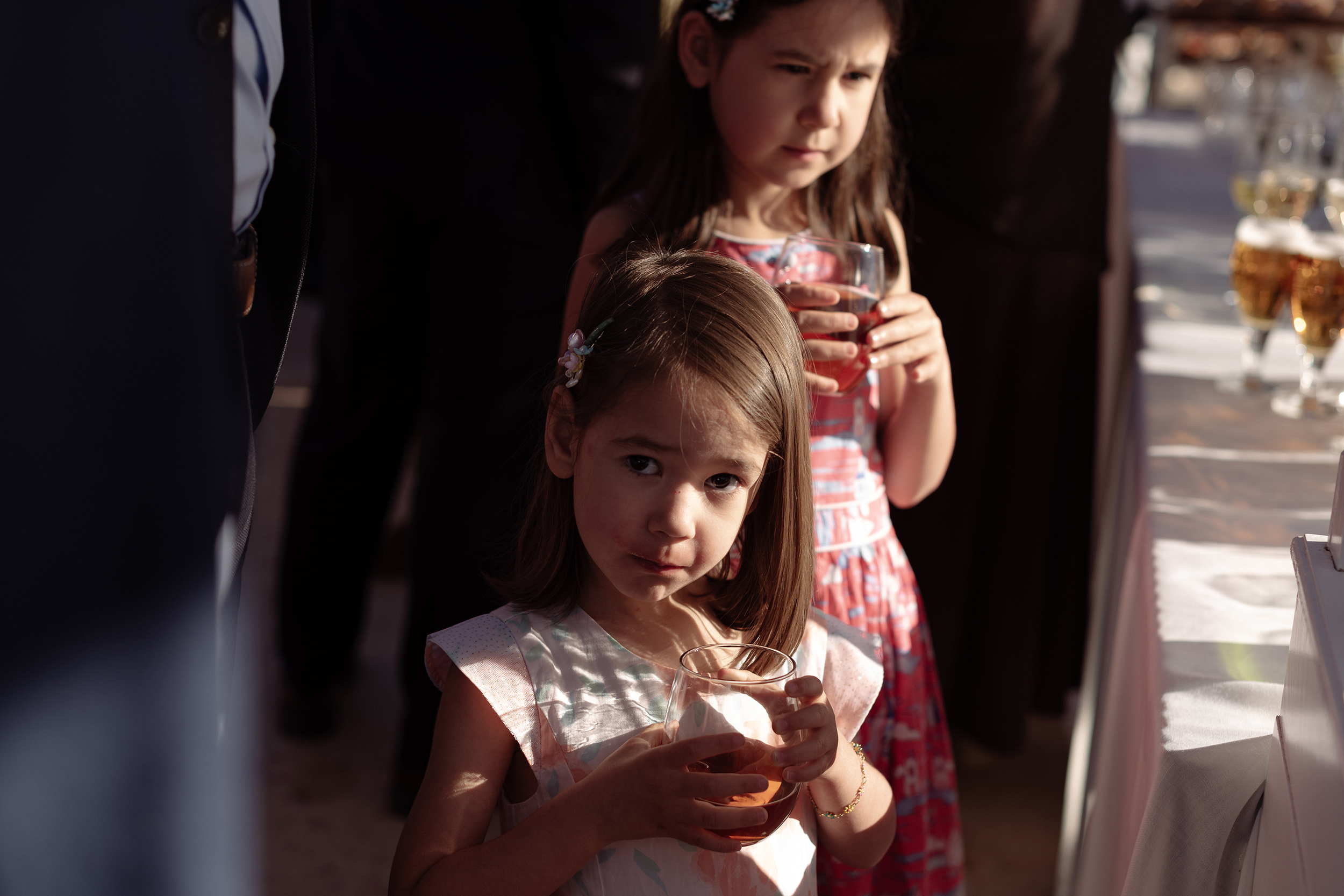 Dos niñas observan la celebración bajo la luz de la tarde