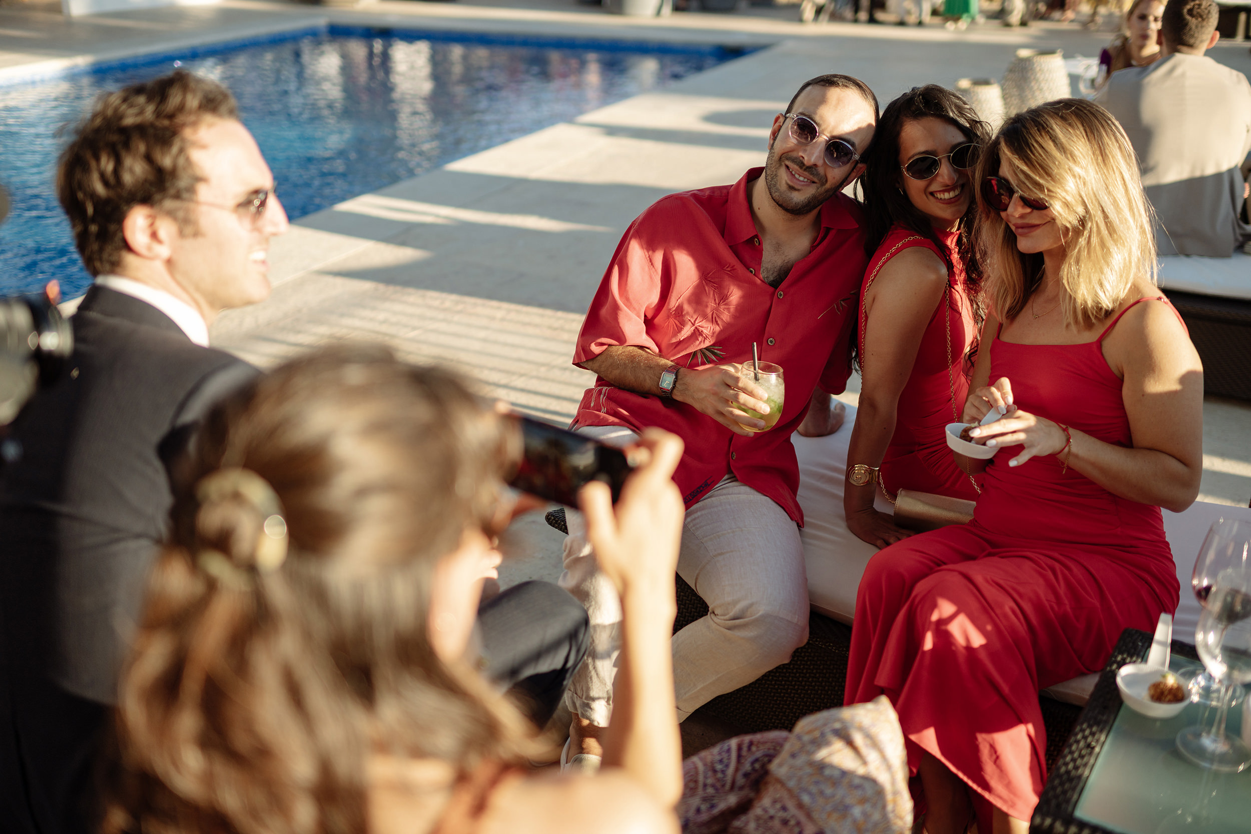 Invitados conversan junto a la piscina durante el cóctel