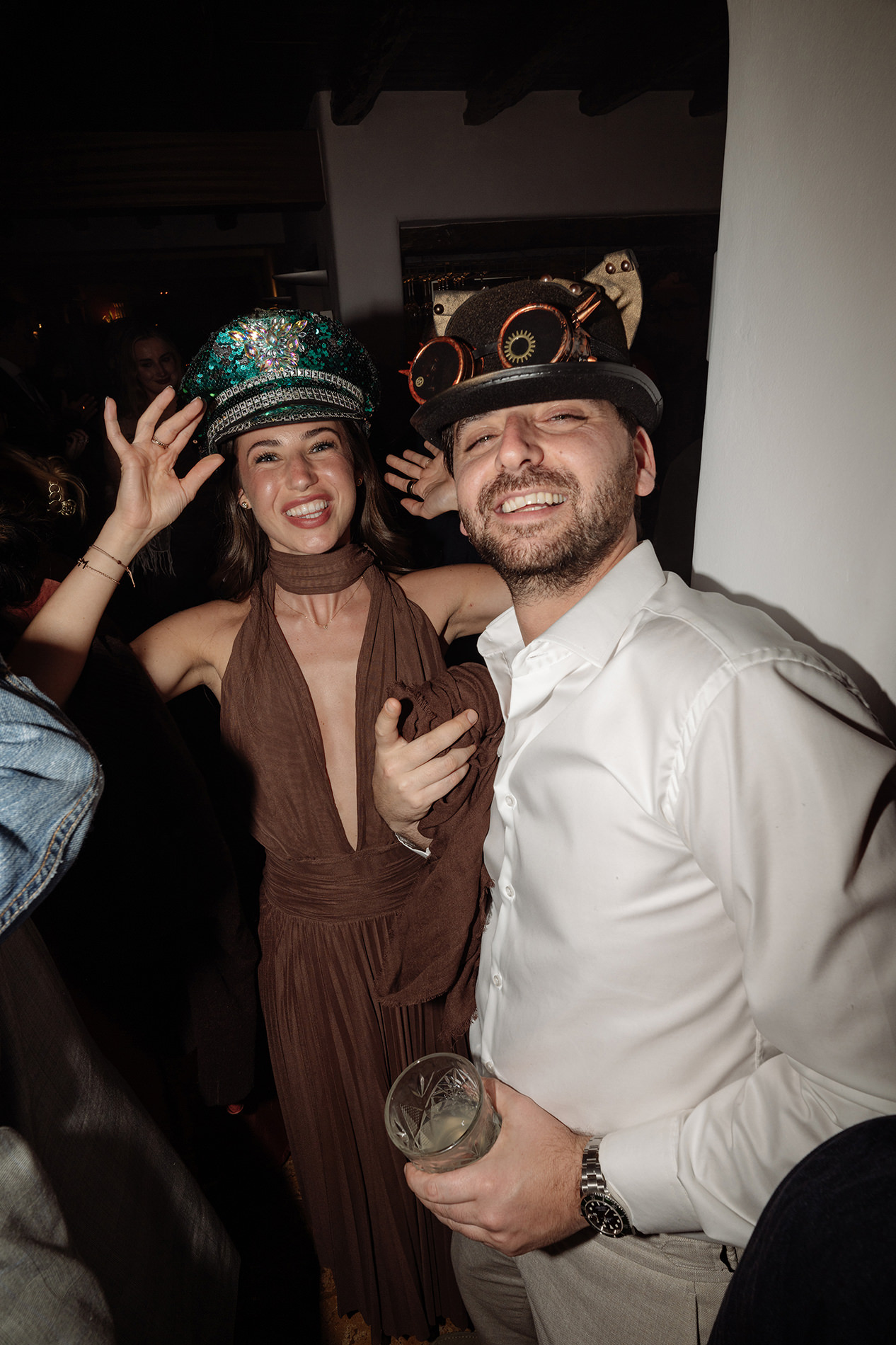 Dos invitados posan con sombreros durante la fiesta