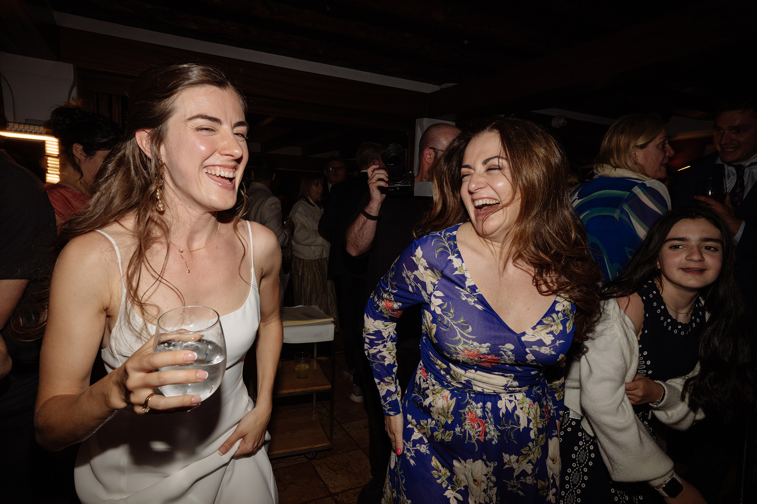 La novia ríe y baila junto a una invitada