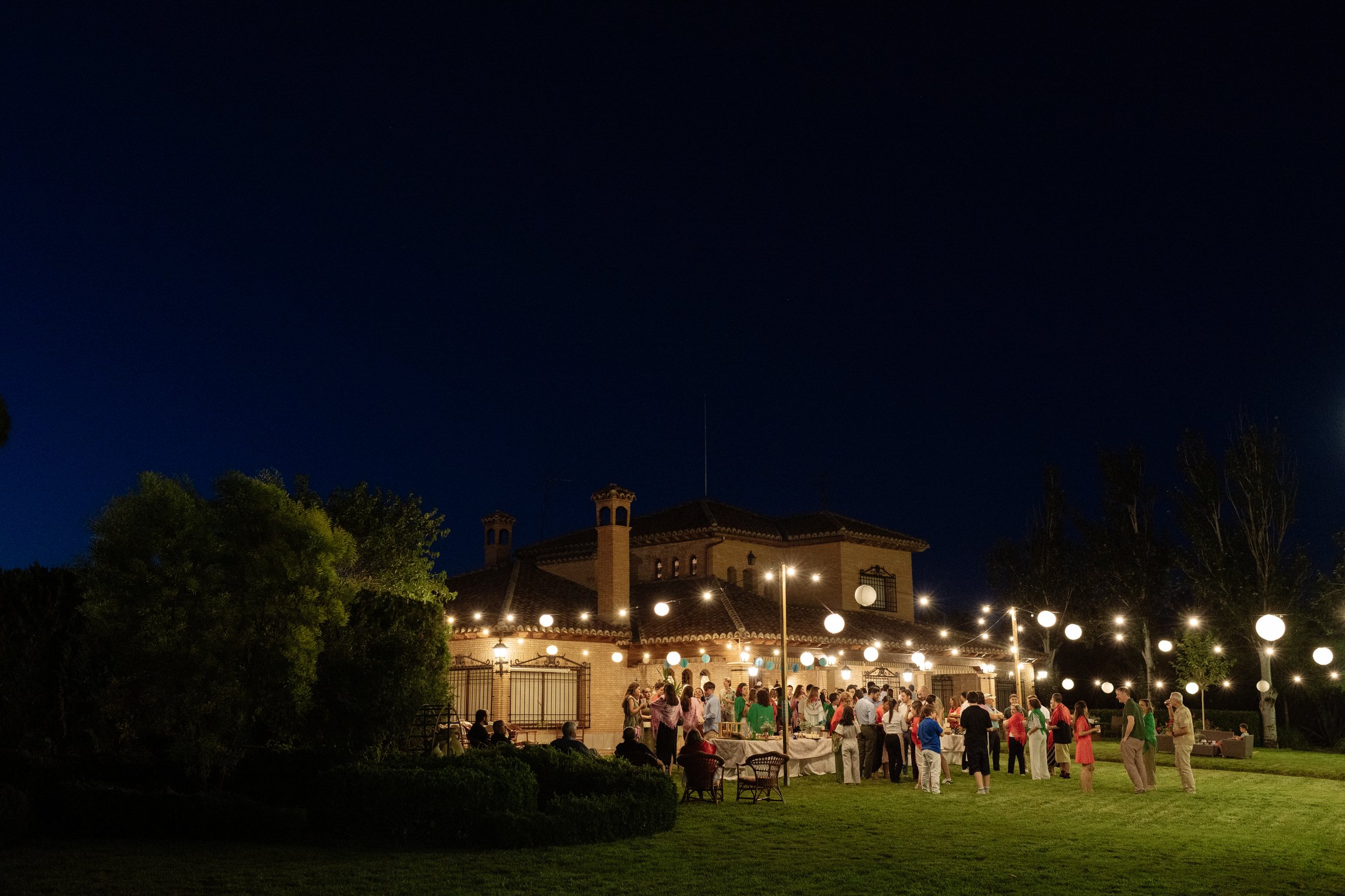 Familiares y amigos comparten una welcome party al aire libre durante la noche